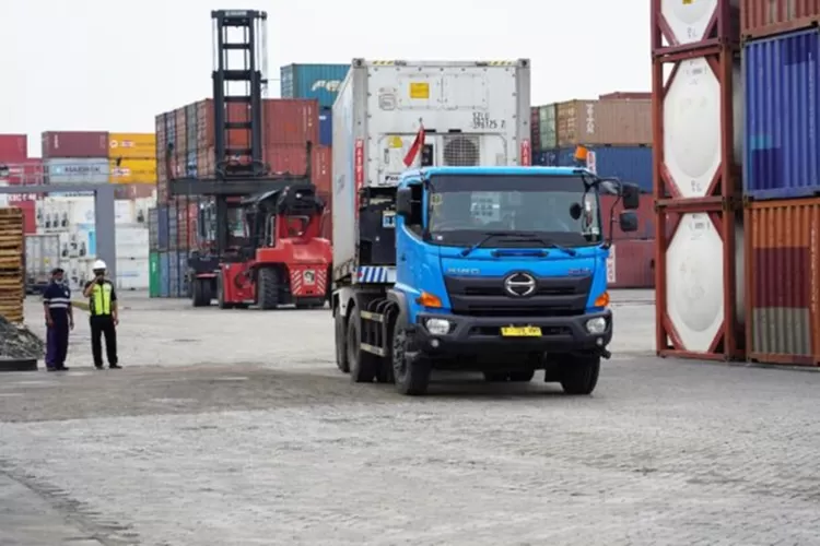 Seorang pengusaha UMKM tersenyum sambil menunjukkan produknya yang siap ekspor