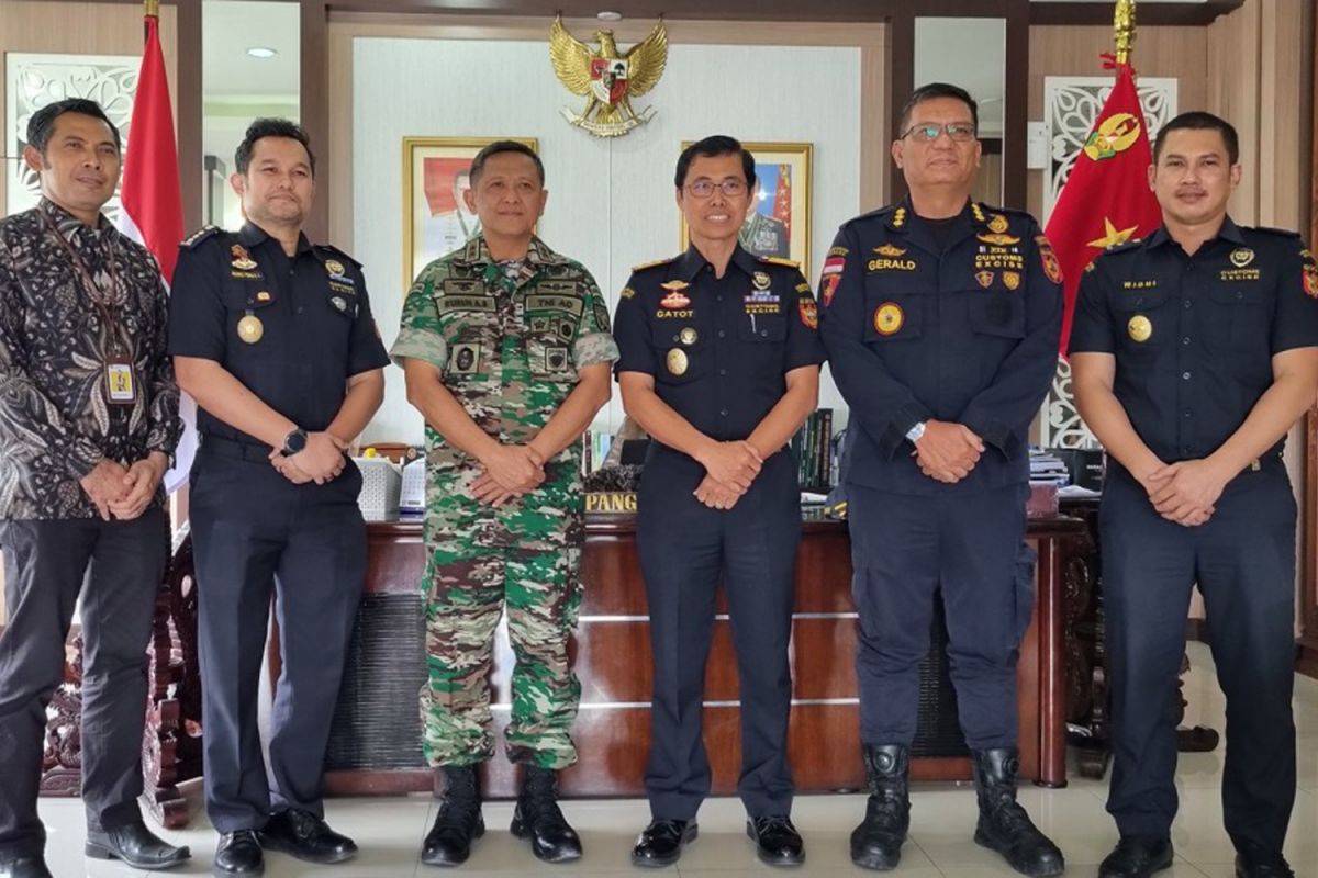 Pejabat Bea Cukai, TNI, dan Polri berdiri bersama di depan spanduk sinergi