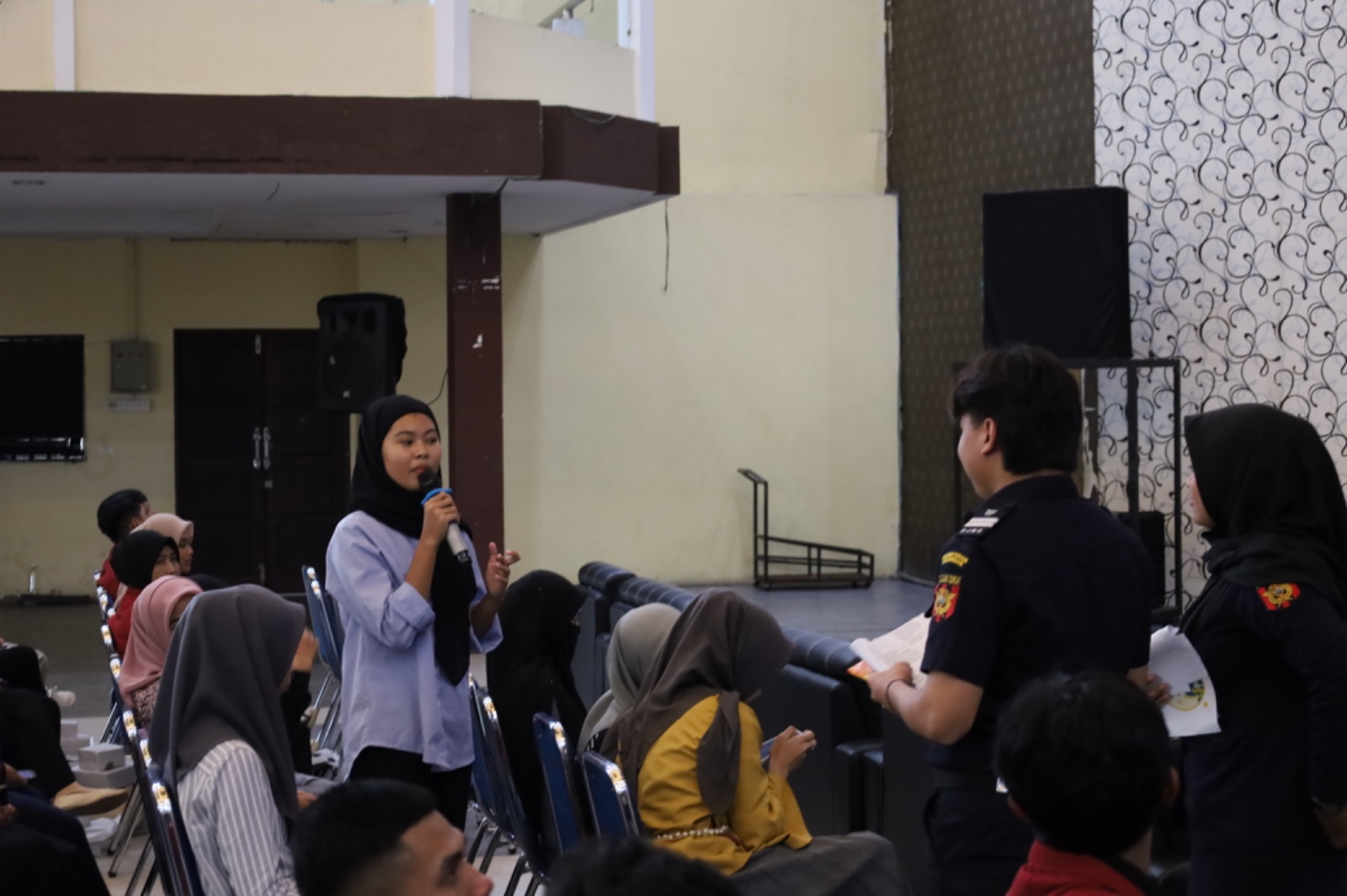 Petugas Bea Cukai memberikan materi di depan mahasiswa di sebuah auditorium